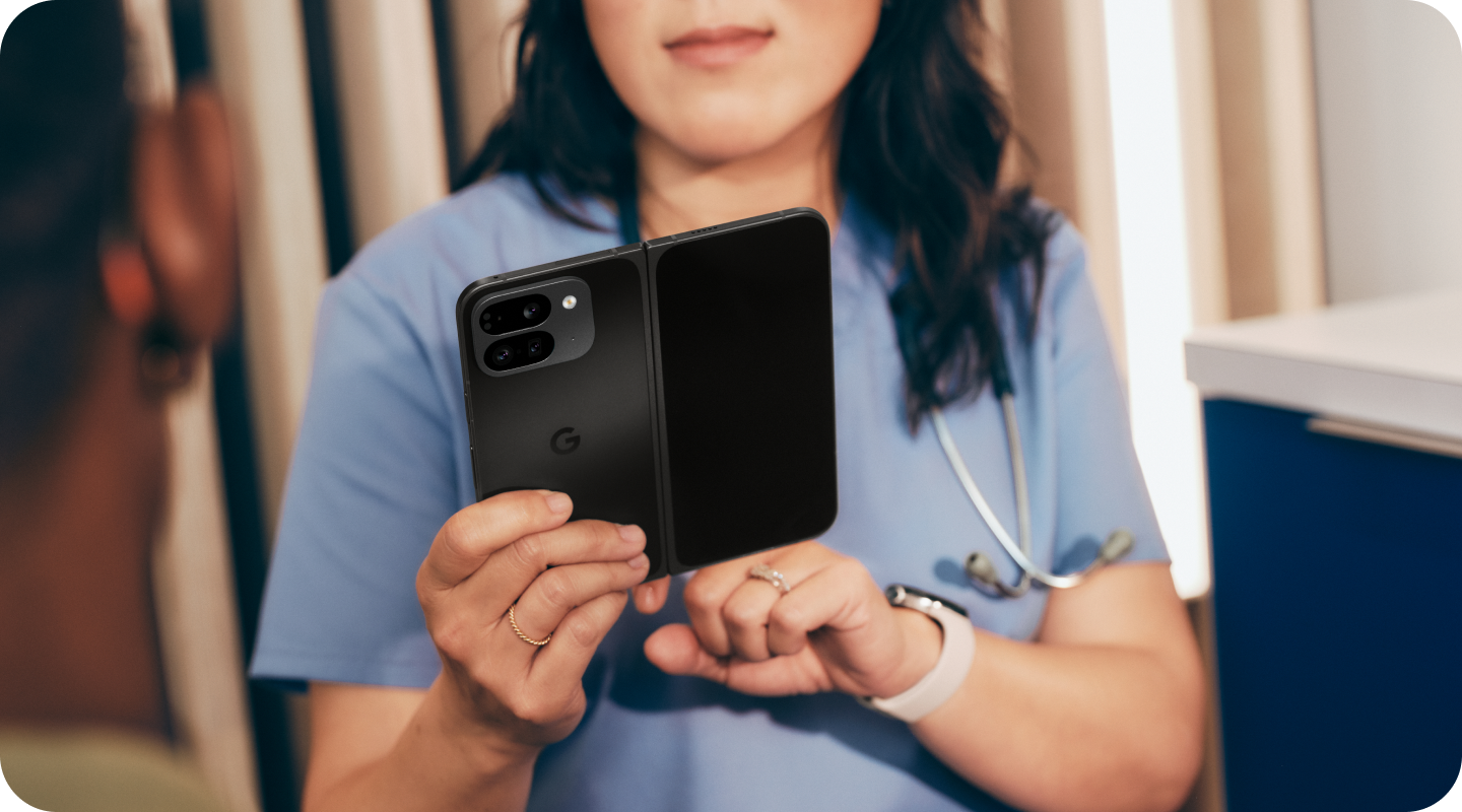A nurse looking at her Pixel 9 Pro Fold phone at work.