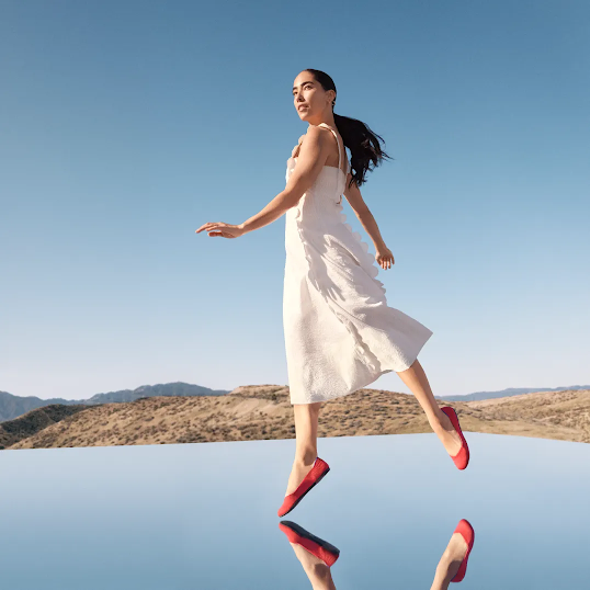 Ein Model mit Schuhen von Rothy's steht über einem Spiegel in der Wüste.
